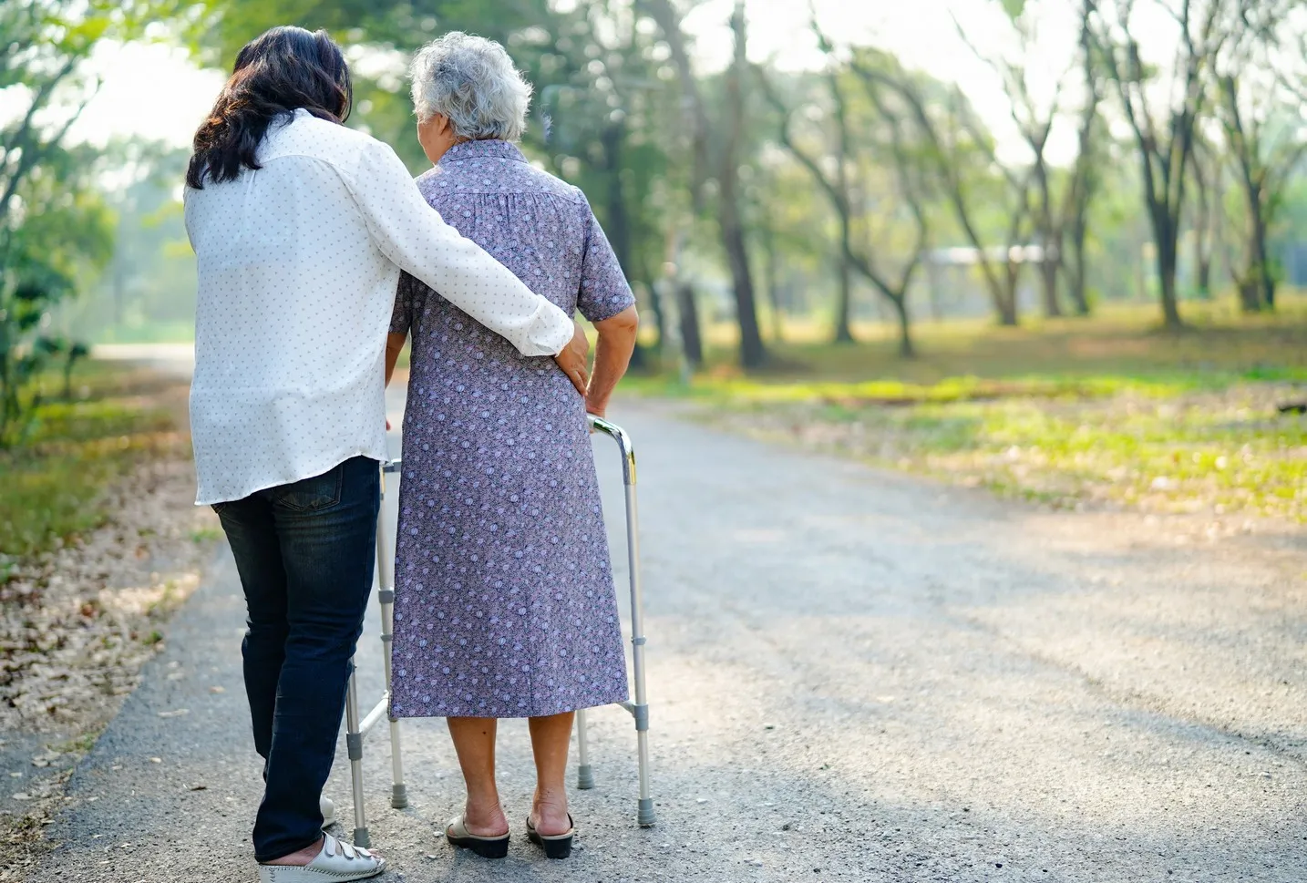 Hilfe und Pflege Asiatische Senioren oder ältere Frauen nutzen einen Gehhilfe mit guter Gesundheit, während sie in einem fröhlichen, frischen Urlaub im Park spazieren gehen.